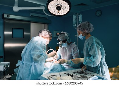 Medical team in the operating room, dark background. The theater of the operating room, an international team of professional doctors in a modern operating room are conducting an operation. Saving - Powered by Shutterstock