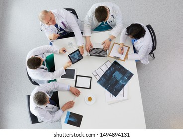 Medical Team Sitting And Discussing At Table, Top View