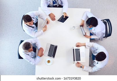 Medical Team Sitting And Discussing At Table, Top View