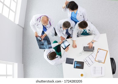 Medical Team Sitting And Discussing At Table, Top View