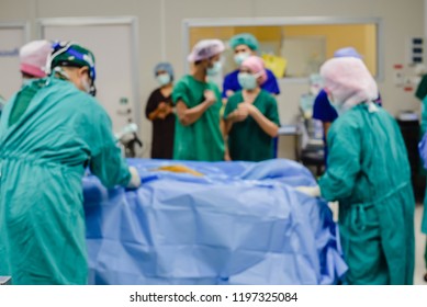Medical team of surgeons in hospital surgery for treatment in operating room blurred.