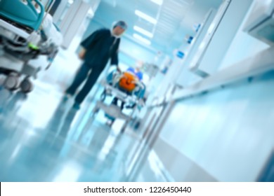 Medical team transports patient on gurney in the hospital hall, unfocused background. - Powered by Shutterstock