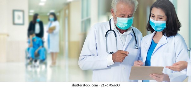 Medical Team Wearing Medical Masks Standing On Hallway While Consulting At Hospital .Two Doctor Discussing Patient Case Before Operation.Medical Health Care Emergency Department Concept