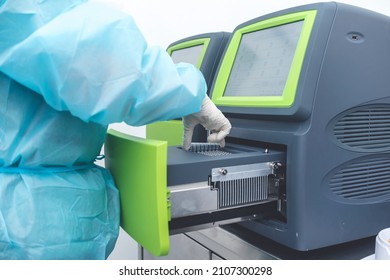 A Medical Technician Places Covid-19 Test Samples Into A PCR Machine, Also Known A Thermal Cycler, In A Cleanroom At A Testing Laboratory.