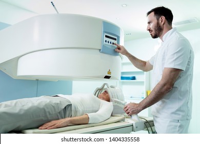 Medical Technician Starting Head MRI Scan Procedure Of A Female Patient In The Hospital. 