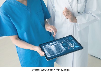 Medical Technology Concept. Doctor And Nurse Watching Electronic Medical Record.