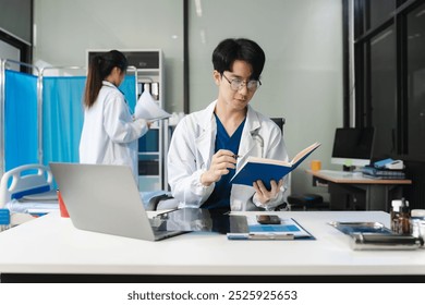 Medical Technology Concepts. male doctor reviews patient records on smartphone and desktop PC. - Powered by Shutterstock