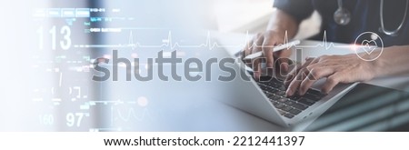 Medical technology, healthcare and medicine concept. Cardiologist doctor working on laptop computer with EKG heartbeat, vital signs monitoring on virtual screen, health technology background