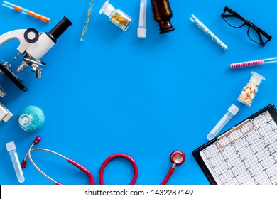 Medical Tests On Work Table Of Doctor With Microscope, Cardiogram, Test Tube On Blue Background Top View Copyspace