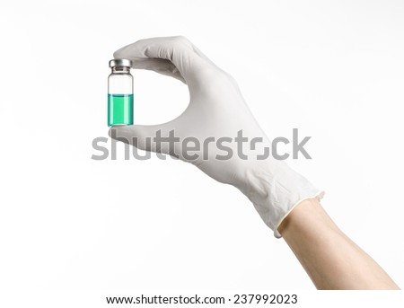 Medical theme: doctor's hand in a white glove holding a blue vial of liquid for injection isolated on white background