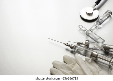 Medical Tools: Vintage Glass Syringes, Ampules, Rubber Gloves And Stethoscope On Grey Background. 