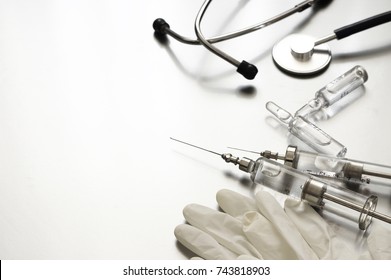 Medical Tools: Vintage Glass Syringes, Ampules, Rubber Gloves And Stethoscope On Grey Background. 