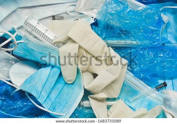 Medical trash. Coronavirus protection equipment\
in medical waste bin. Used hazardous face masks and sterile gloves.\
Doctor uniform for patient treatment in hospital. Prevention the\
spread of COVID-19.