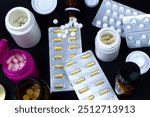 Medical treatment or designer drugs concept. Lots of drugs on black background. Various pills, tables and capsules with blisters and drug bottles.