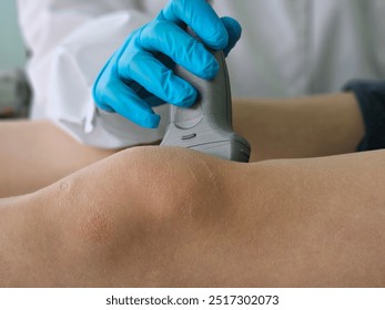 Medical ultrasound examination of the knee being conducted by a healthcare professional in a clinical setting - Powered by Shutterstock