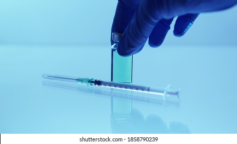 Medical Vaccine Scientist Holding The Glass Vial With Vaccine. Concept Of Developing Research Of Vaccine Against Coronavirus, COVID-19. Pre-clinical Evaluation, Clinical Phase Trials Development Test.