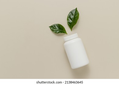 Medical Vitamin Or Pills Bottle Mockup With Green Leaves Top View, Copy Space. Natural, Eco Friendly Supplement