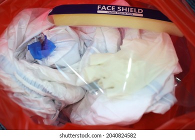 Medical Waste Or Clinical Waste Disposal Is A Hazardous Waste Clear Used PPE Suit (Personal Protective Equipment)  Medical Masks Gloves Face Shield And Sock In Red Garbage Plastic Bag