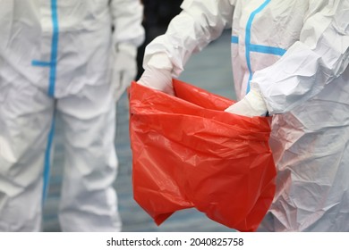 Medical Waste Or Clinical Waste Disposal Is A Hazardous Waste Clear Used PPE Suit (Personal Protective Equipment)  Medical Masks Gloves Face Shield And Sock In Red Garbage Plastic Bag