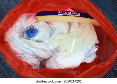 Medical Waste Or Clinical Waste Disposal Is A Hazardous Waste Clear Used PPE Suit (Personal Protective Equipment)  Medical Masks Gloves Face Shield And Sock In Red Garbage Plastic Bag