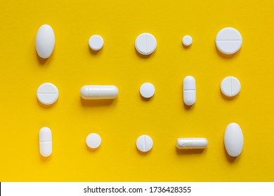 Medical white pills on a yellow background. Pharmaceutical concept - Shutterstock ID 1736428355