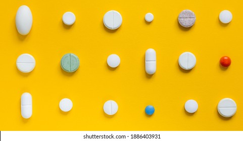 Medical white pills on a yellow background. Pharmaceutical concept - Shutterstock ID 1886403931