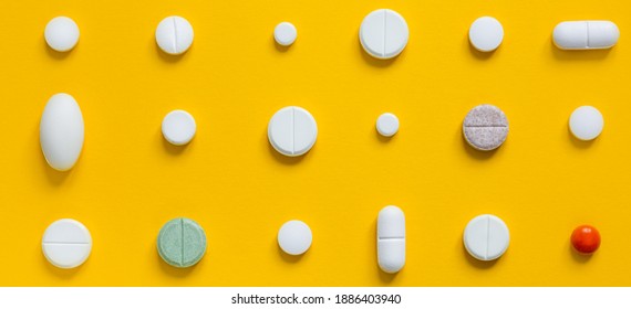Medical white pills on a yellow background. Pharmaceutical concept - Shutterstock ID 1886403940