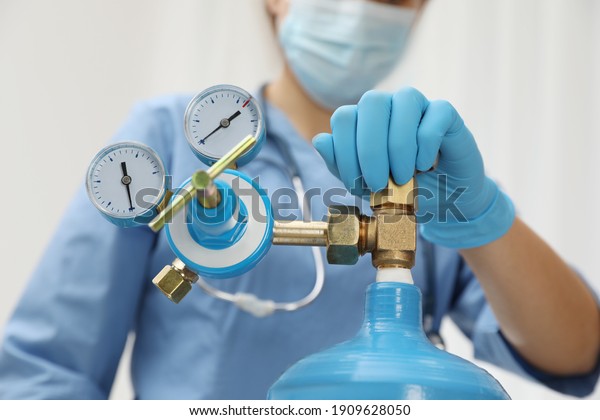 Medical worker checking oxygen tank in hospital\
room, closeup