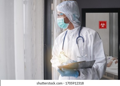 Medical Worker Or Doctors In The Protective Suits And Masks In COVID 19 Restricted Area And Looking For Coronavirus Infected Patient's Laboratory Report.