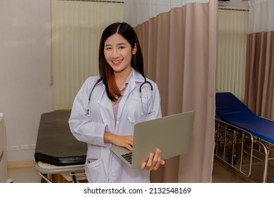 Medical Worker Or A Female Doctor At A Hospital Working In An Outpatient Room Holding A Digital Laptop For Examination : Portrait Elegant Asian Female Doctor In Hospital Smiling And Looking At Camera.