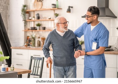 Medical worker helping his patient to move around the apartment