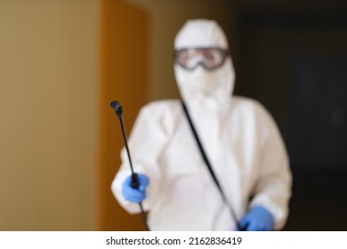 Medical worker in protective clothing and medical mask cleans and disinfects room - Powered by Shutterstock