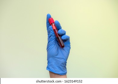 Medical worker in protective costume holding red test tubes in hands in laboratory - Shutterstock ID 1623149152