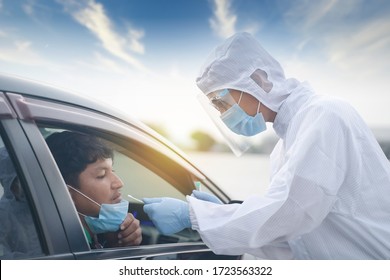 Medical worker in protective suit screening driver to sampling secretion to check for Covid-19. Drive thru test coronavirus fast track. Concept prevention coronavirus outbreak. - Shutterstock ID 1723563322