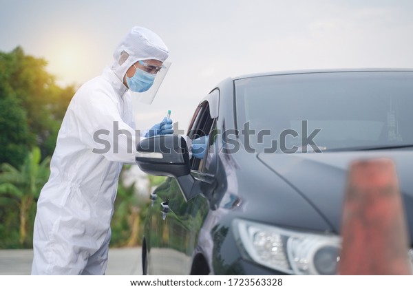 Medical worker in\
protective suit screening driver to sampling secretion to check for\
Covid-19. Drive thru test coronavirus fast track. Concept\
prevention coronavirus\
outbreak.