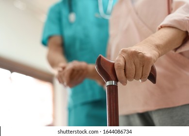 Medical Worker Taking Care Of Elderly Woman In Geriatric Hospice, Closeup