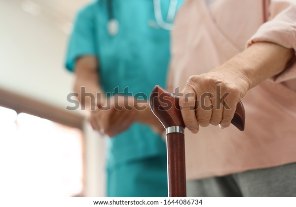 Medical worker taking care of elderly woman in\
geriatric hospice,\
closeup