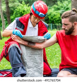 Medical Worker Treating Burns On Male's Hand. First Aid Treatment Outdoors. First Aid Practice