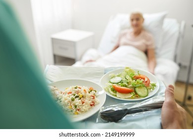 Medical worker walking with two plates of food - Powered by Shutterstock