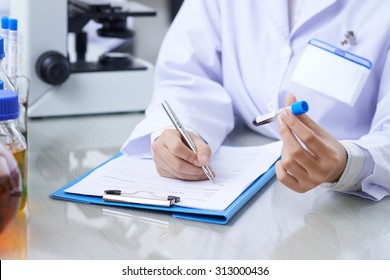 Medical Worker Writing Results Of Blood Test Into Medical Card Of The Patient