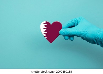 Medical Workers Hand Wearing Surgical Glove Holding Qatar Flag Heart