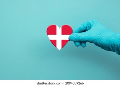 Medical Workers Hand Wearing Surgical Glove Holding Denmark Flag Heart