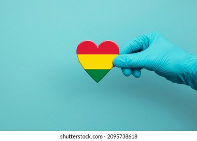 Medical Workers Hand Wearing Surgical Glove Holding Bolivia Flag Heart