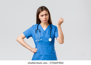 Medical Workers, Healthcare, Covid-19 And Vaccination Concept. Angry And Grumpy Young Female Nurse, Doctor Scolding Young Patient Breaking Quarantine Rules, Shaking Fist In Threat