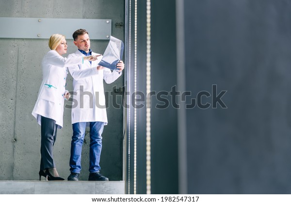 Medical workers in the\
hospital are examining X-rays. Medical men consult each other by a\
woman looking at an x-ray image. Two doctors look at an MRI scan\
and discuss it.