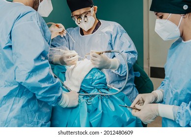 Medical workers performing surgery inside operation room at hospital - Focus on center doctor hands - Shutterstock ID 2012480609