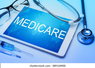 Medicare word on tablet screen with medical equipment on background