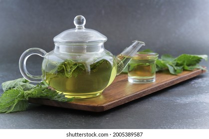 Medicated nettle tea and fresh green nettle leaves.