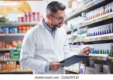 Medication Is His Specialty. Shot Of A Mature Pharmacist Doing Inventory In A Pharmacy.