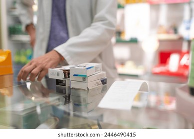 Medications stacked on a pharmacy counter, ready to be sold. Represents a typical scene in the daily routine of a pharmacy - Powered by Shutterstock